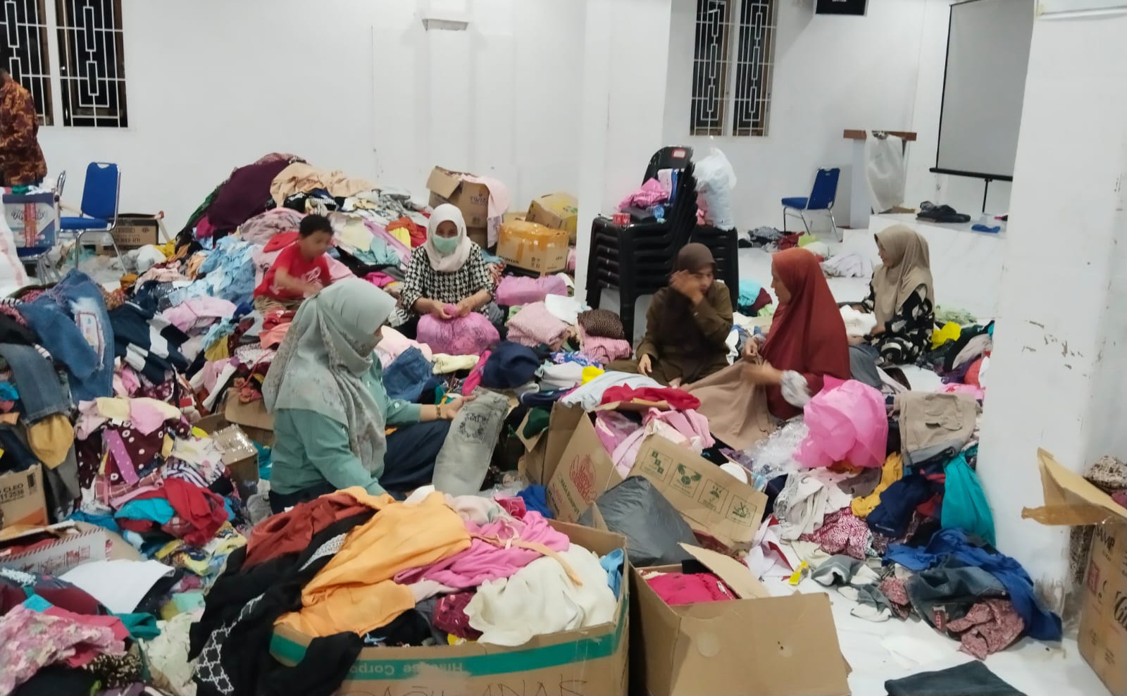 Ibu-Ibu Warga Kajhu Sortir Pakaian Layak Pakai di Kantor Desa untuk Korban Banjir
